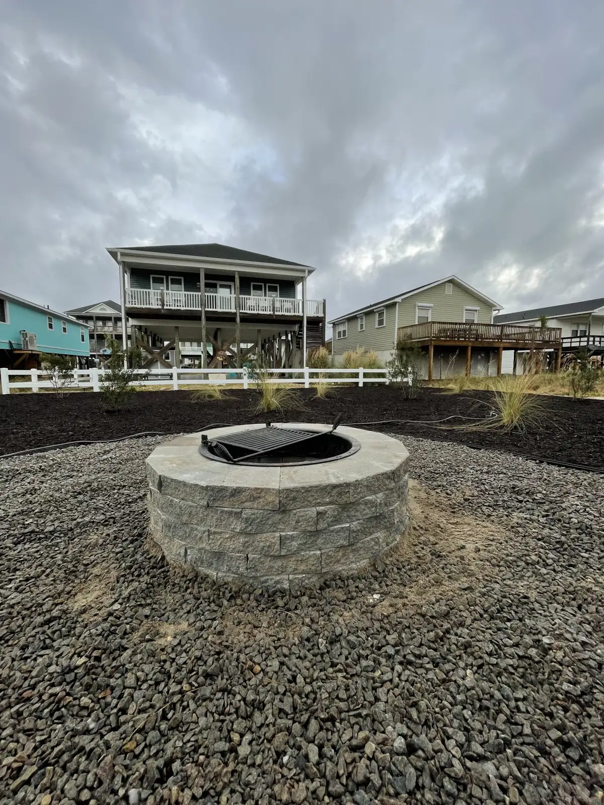 Luxury outdoor living space with paver patio and fire feature in coastal North Carolina