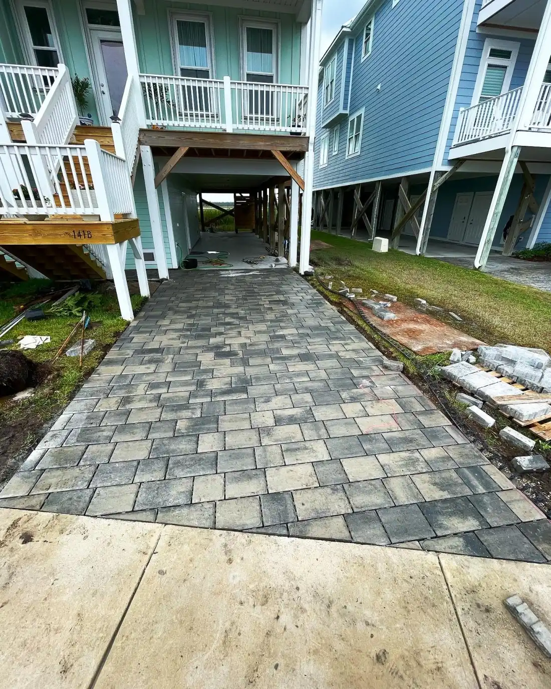 Custom stone fire pit with paver patio and Adirondack seating in coastal NC